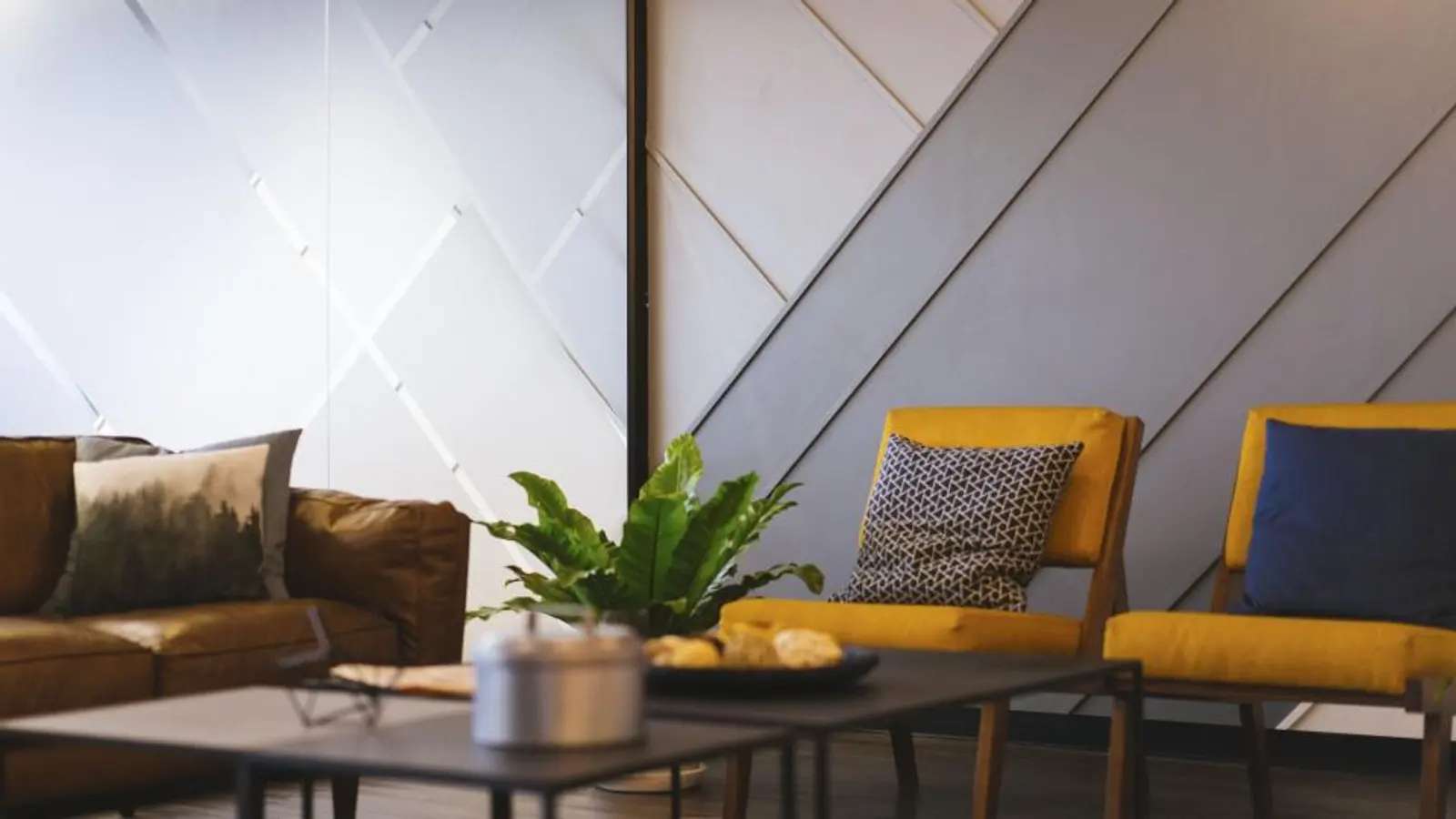 Wohnzimmer mit gelben Sesseln, Couchtisch und Pflanze