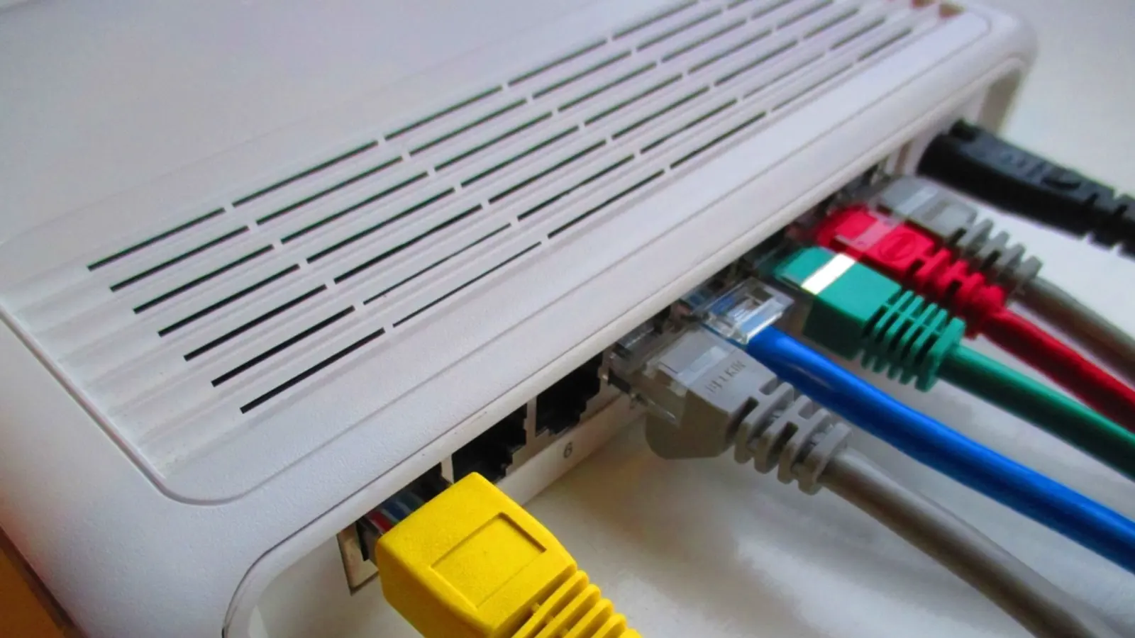 The back of a white router with coloured network cables plugged in