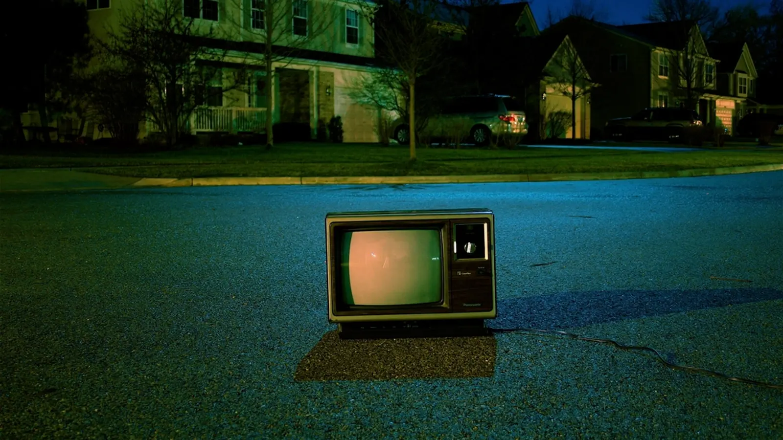 Alter Röhrenfernseher steht nachts auf einer Straße