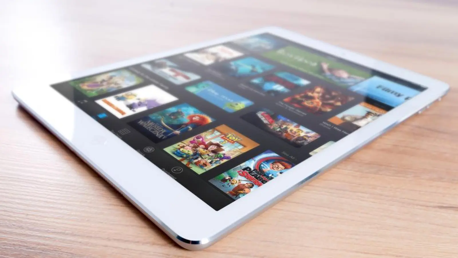 A tablet on a wooden table showing rows of film posters