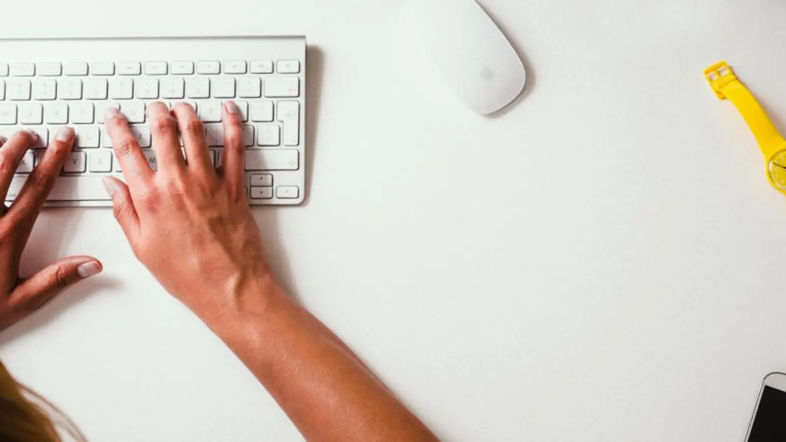 Hands typing on a white keyboard