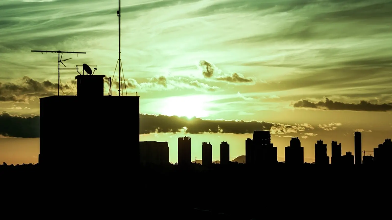 Silueta de antenas de televisión sobre una azotea al atardecer