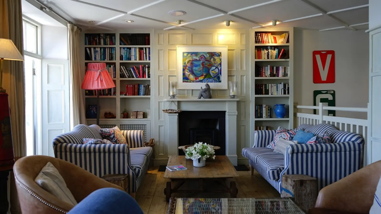 Salon cosy avec bibliothèque, canapé et cheminée