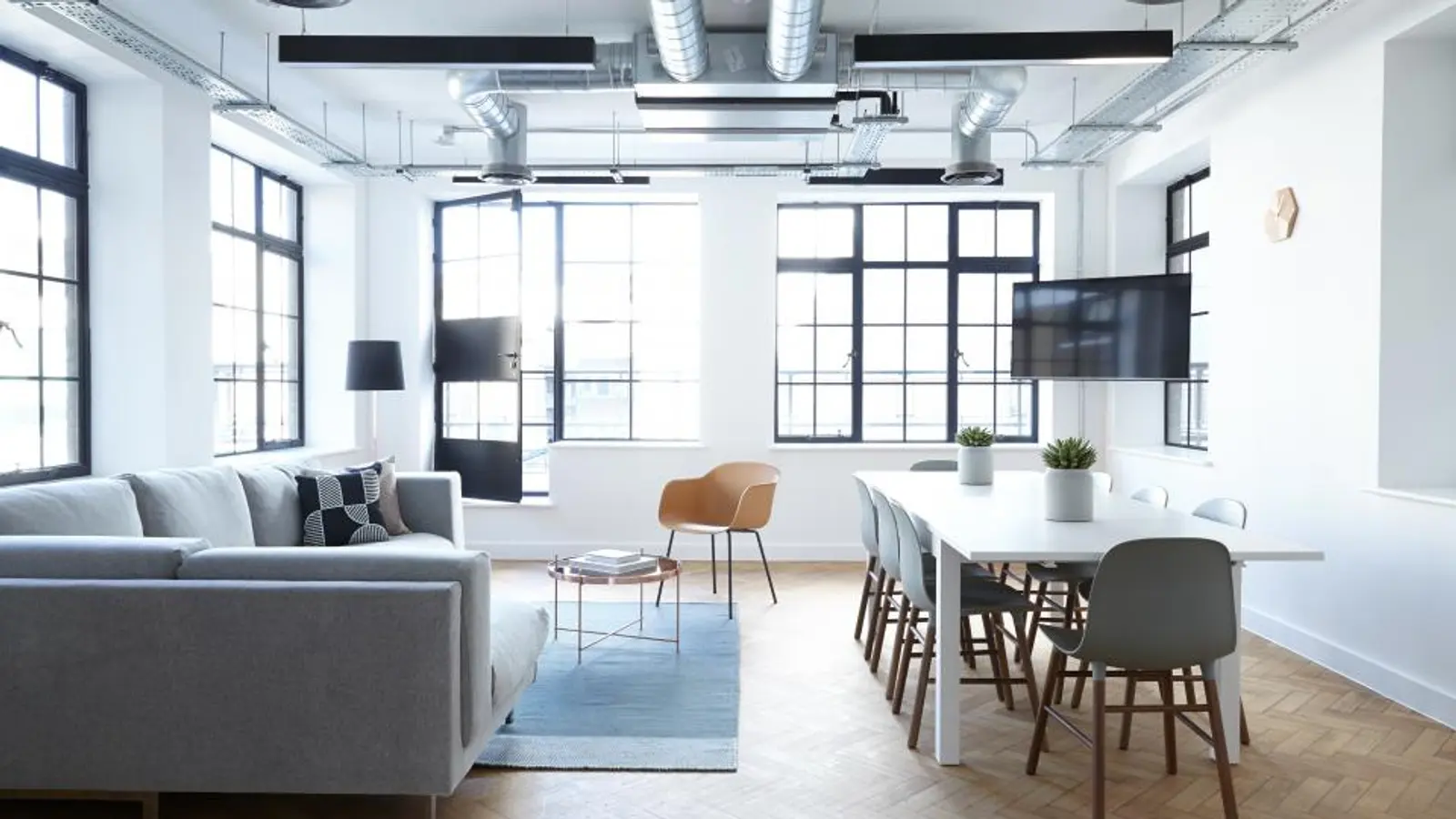 Loft lumineux avec un téléviseur fixé au mur et une grande table