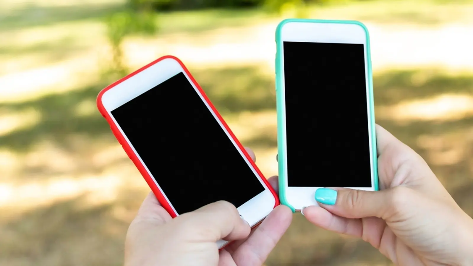 Deux smartphones tenus côte à côte, écrans éteints