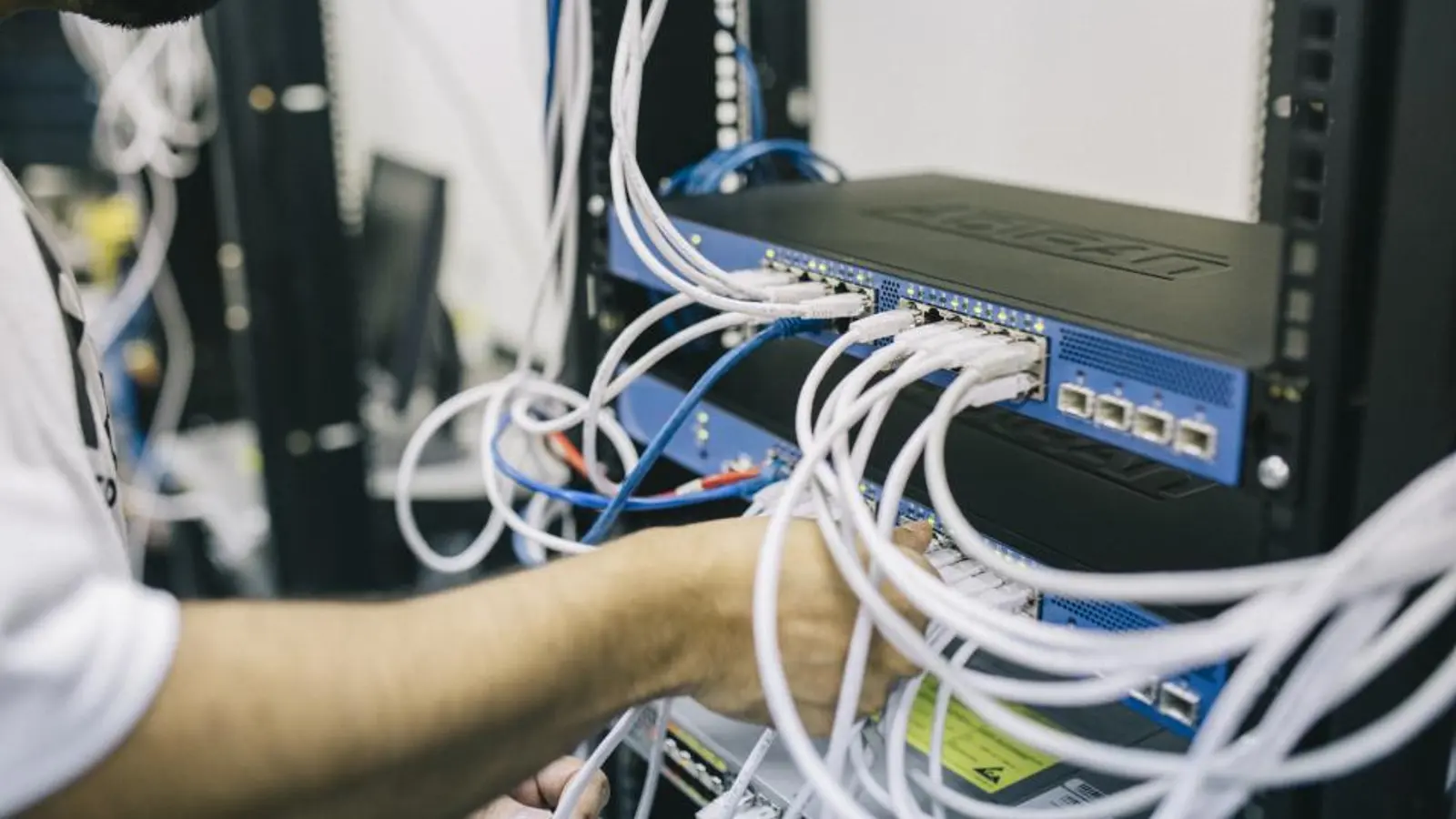 Tecnico che collega cavi di rete in un armadio rack