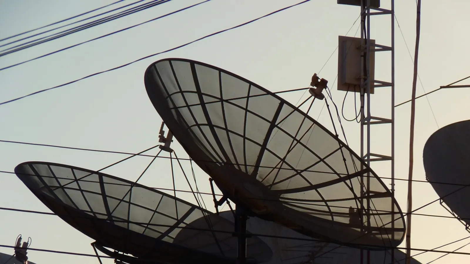 Parabole satellitari su un edificio tra i fili