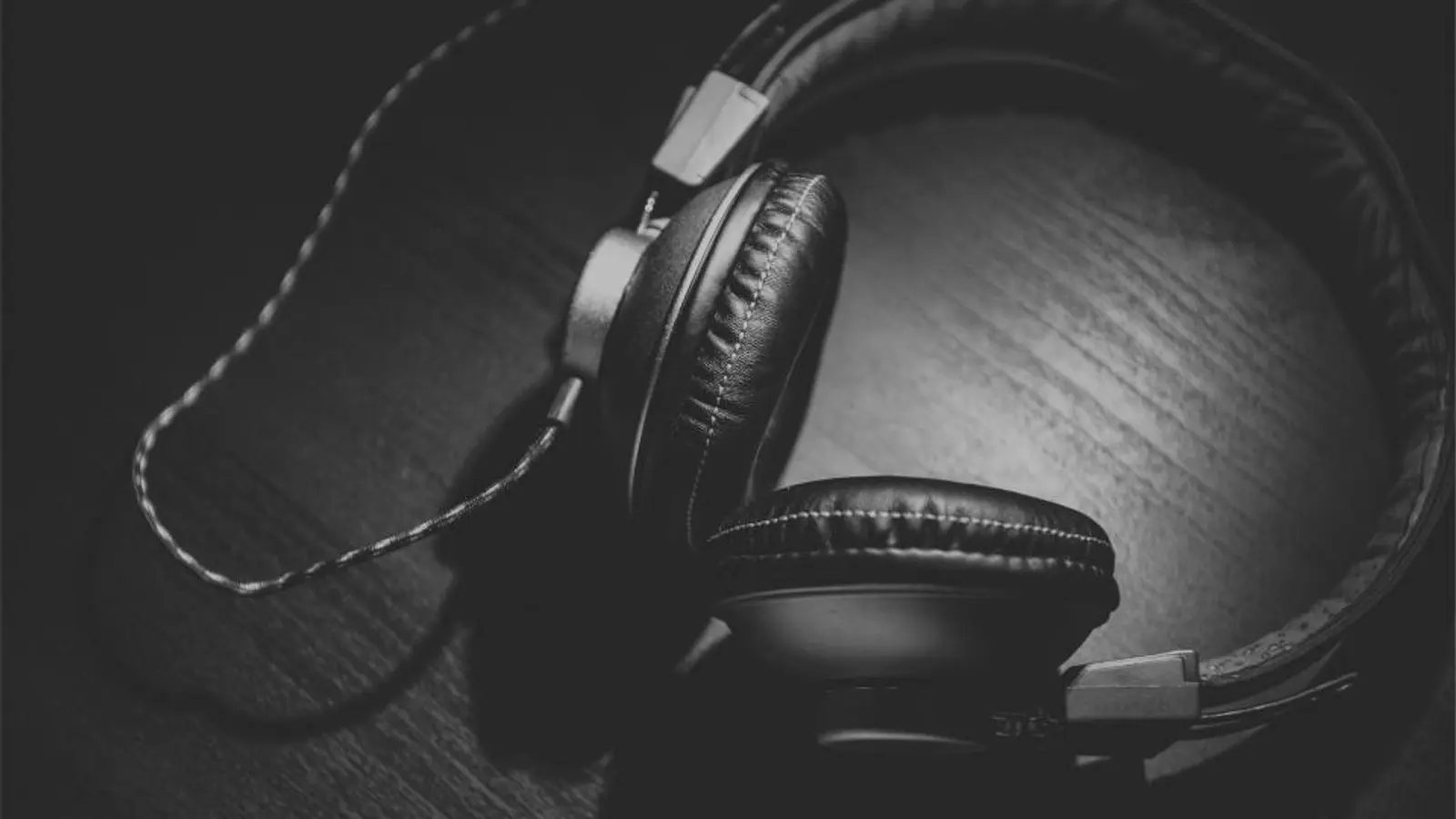A pair of black headphones on a dark surface
