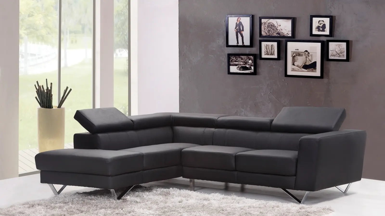 A dark grey corner sofa in a minimalist room