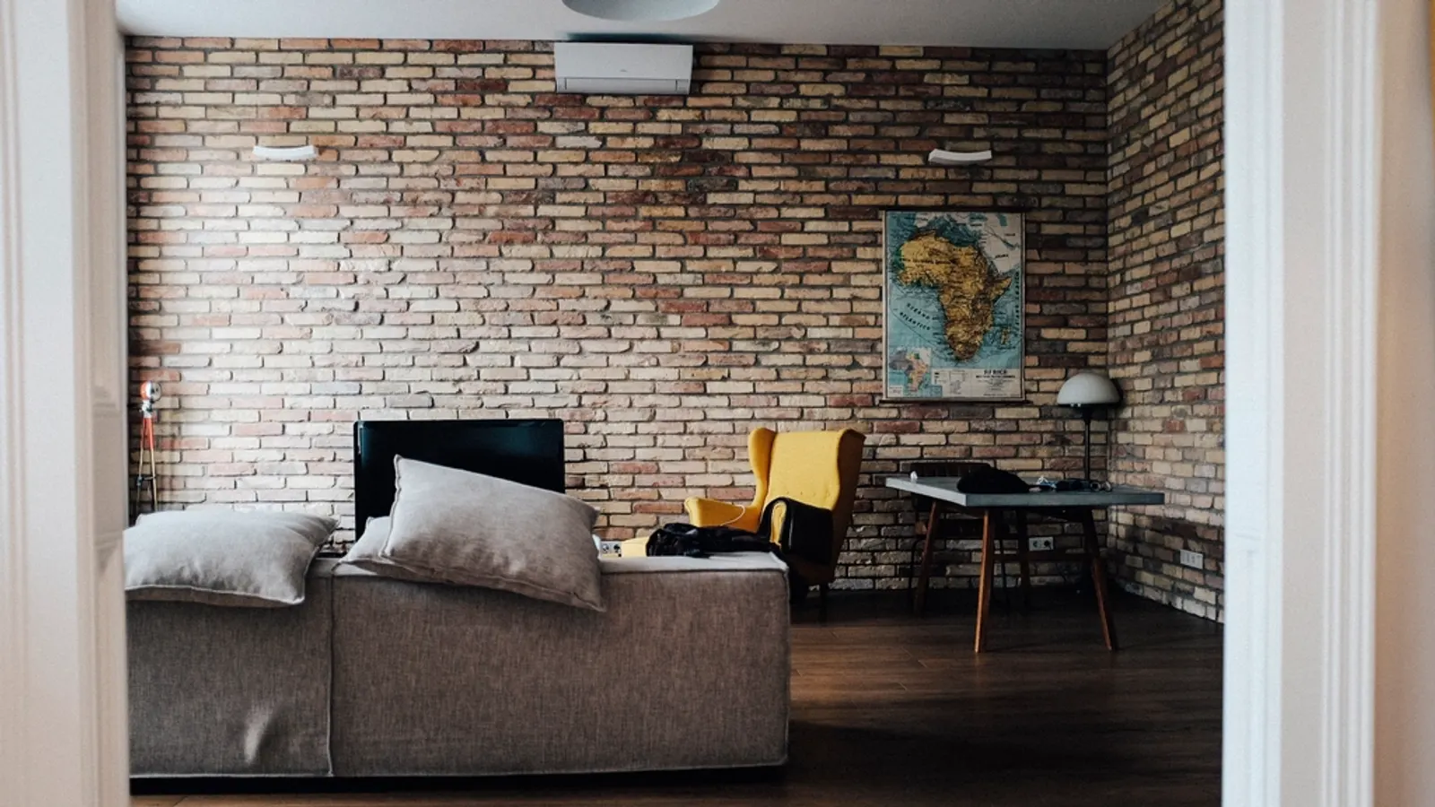 A bright living room with a sofa and a TV on the wall